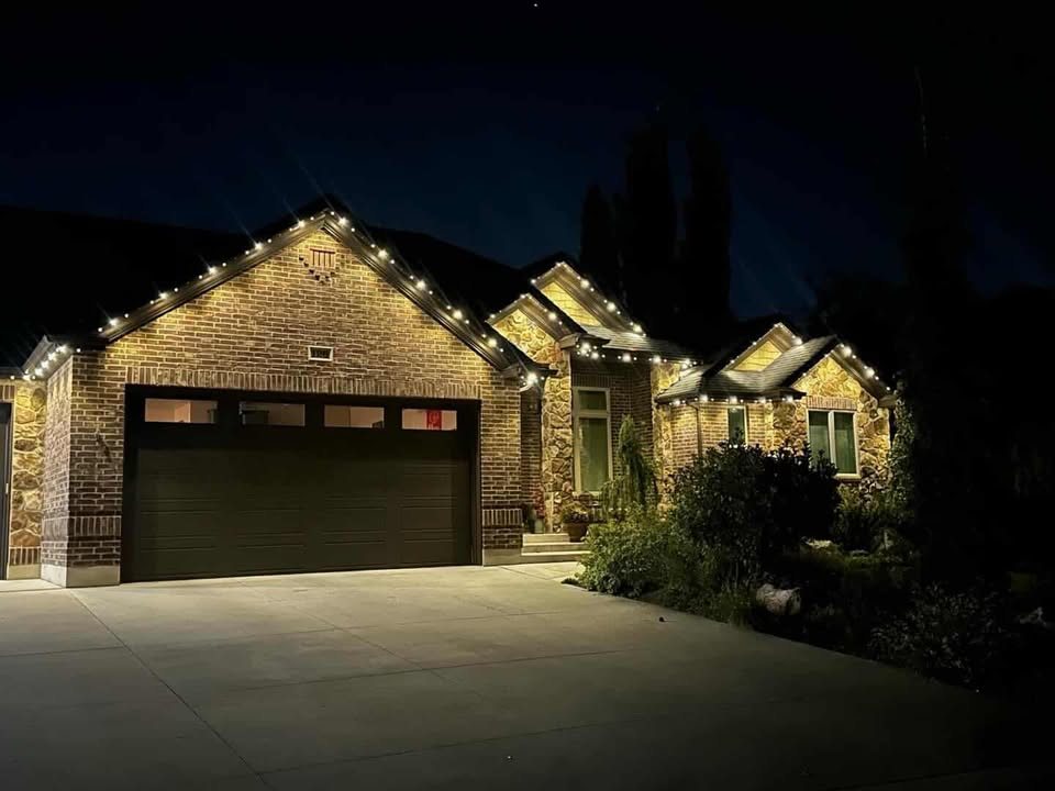 Two-peak brick and stone home with crisp white Ember roofline lighting